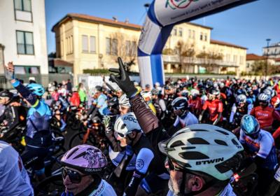 Ciclisti entusiasti pronti alla partenza, sotto un cielo limpido.
