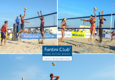 Giocatori di beach volley competono intensamente sulla sabbia sotto un cielo azzurro.