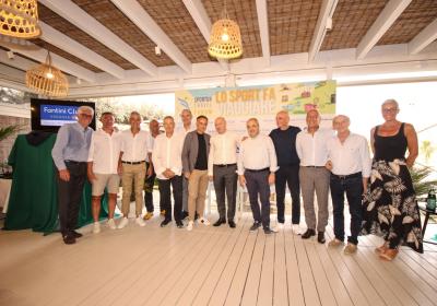 Gruppo sorridente in un evento elegante, atmosfera conviviale e luminosa.